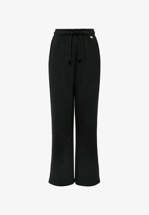 Czarne dresy wykonane z miękkiego materiału, z elastycznym pasem na sznurki, szerokimi nogawkami oraz małym metalowym akcentem z przodu.