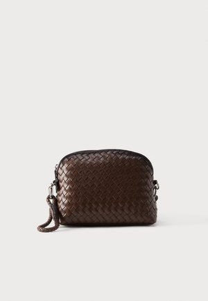 Pochette-bracelet en cuir tressé marron foncé avec fermeture éclair et une lanière tressée attachée d'un côté.