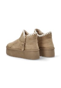 Botas de ante beige hasta el tobillo con forro suave, que se extienden por encima del tobillo, con una correa decorativa y un borde en zigzag en el cuello.