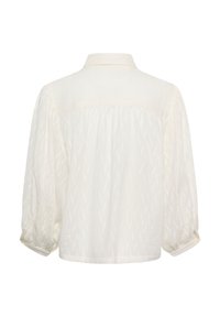 Chemise blanche boutonnée avec un motif texturé, dotée d'un col et de manches amples, avec une coupe décontractée.