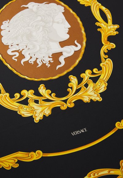 Črna tkanina s kompleksnim belim in rjavim vzorcem ter zlatimi detajli. Vključuje stiliziran profil in besedilo "VERSACE".