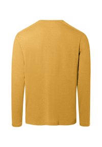 Chemise à manches longues en moutarde, fabriquée en tissu doux, avec un col rond simple et un ourlet droit sans détails supplémentaires.