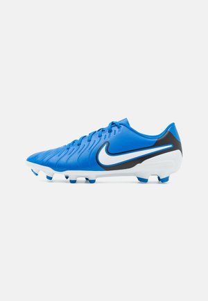 Crampon de football Nike bleu et blanc avec accents noirs et crampons moulés pour terrain ferme, vu de côté.