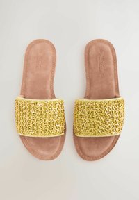 Lamedatud sandaalid kollase helme pealmise osaga, millel on tekstureeritud pind, beezist nubukist tallaga. Ilma kontsata või täiendavate kaunistusteta.