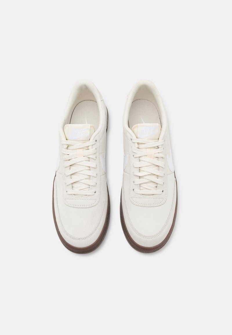Białe zamszowe sneakersy o fakturowanym wykończeniu, z kremowymi sznurowadłami, wyściełaną wkładką i brązową gumową podeszwą. Subtelne akcenty z logo.