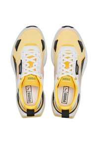 Sneakers atletici con tomaia in mesh gialla, dettagli bianchi, accenti neri e suola imbottita. I lacci si incrociano sulla parte superiore per una vestibilità sicura.