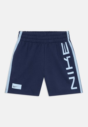 Shorts navy avec taille élastique, accents latéraux bleu clair et logo "NIKE" en blanc bien visible sur le côté. Texture de tissu douce.
