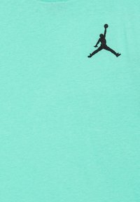 Mentolové tričko vyrobené z měkké bavlny s kulatým výstřihem. Na horní levé straně má vyšitý černý logo Jordan.