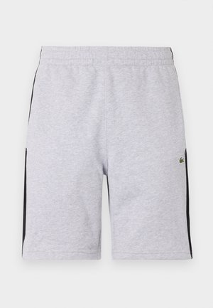 Pantaloni corti in cotone grigio con una striscia laterale nera, vita elastica, taglio fino al ginocchio e un piccolo logo verde sulla gamba sinistra davanti.
