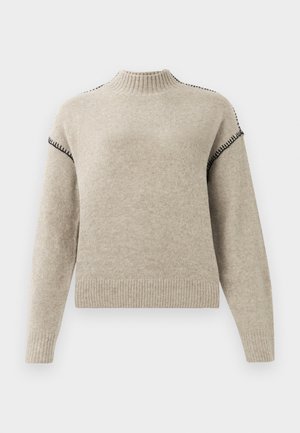 Sweater de malha bege com gola alta canelada, punhos e bainha, apresentando detalhes em ponto de whipstitch preto nos ombros e mangas superiores.