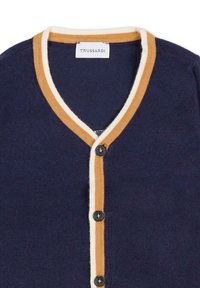Cardigan bleu marine avec un col en V, présentant un col à rayures crème et brun doré et cinq boutons noirs sur le devant. Texture en tricot douce.