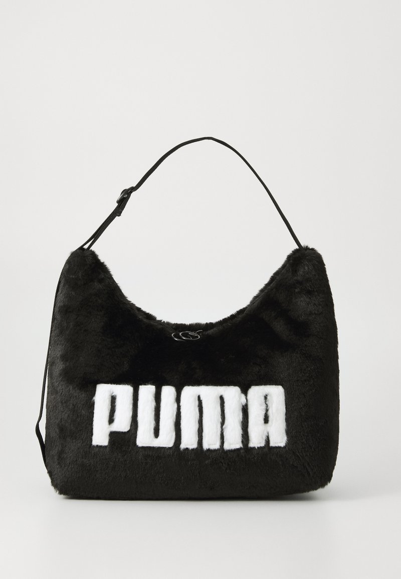 Svart faux fur håndveske med avrundet form, utstyrt med en fremtredende hvit "PUMA"-logo. Den har en justerbar svart stropp. Glatt tekstur.
