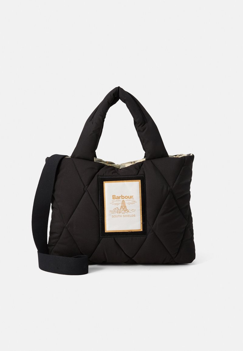 Sac à main matelassé noir avec poignées rembourrées, bandoulière ajustable et un patch avant portant l'inscription "Barbour South Shields".