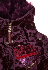 Chaqueta de terciopelo morado con un parche de lentejuelas en forma de corazón, patrón floral y forro de piel sintética en la capucha, con cierre de cremallera y broches.