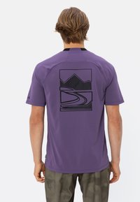 Chemise violette à manches courtes avec un graphique de montagne noire et de route au dos. Fabriquée en matériau respirant avec une texture lisse.