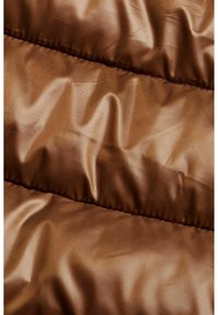 Tessuto trapuntato marrone con una texture lucida e liscia, caratterizzato da cuciture orizzontali che creano motivi ondulati e pieghe sottili.