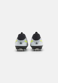 Football boots featuring a sleek design, constructed of black synthetic material with grey accents, reflective yellow stripes, and studded soles.