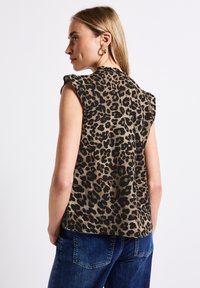 Halenka bez rukávů s potiskem leopardího vzoru v hnědé a černé barvě. Vyrobena z měkké tkaniny s výraznými detaily na ramenních švech.