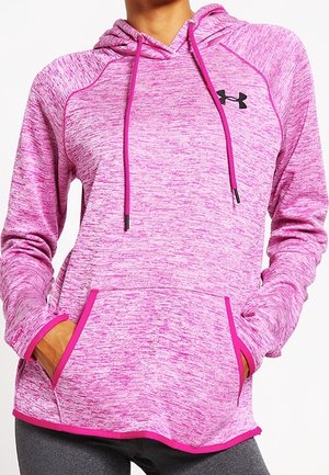 Vrouw draagt een roze gemêleerde hoodie met voorzak, verstelbare trekkoorden en een zwart Under Armour-logo op de borst.