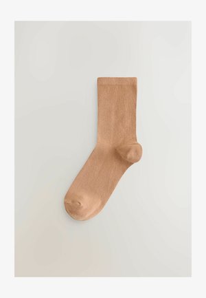 Calcetín hasta la rodilla hecho de un material suave y acanalado en un tono marrón claro, con puntera reforzada y acabado liso.