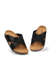 Sandalias negras de tipo slip-on con tiras cruzadas, suela texturizada de corcho y una plantilla ligeramente acolchada en marrón. Material superior sintético suave.