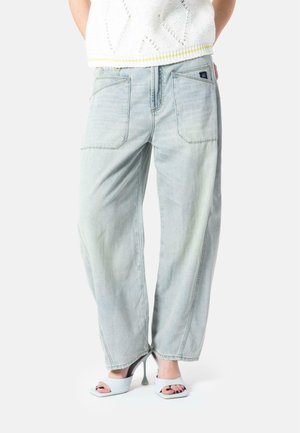 Light blue, high-waisted jeans with a relaxed fit, featuring back pockets and subtle fading. Paired with light-colored block-heeled sandals.