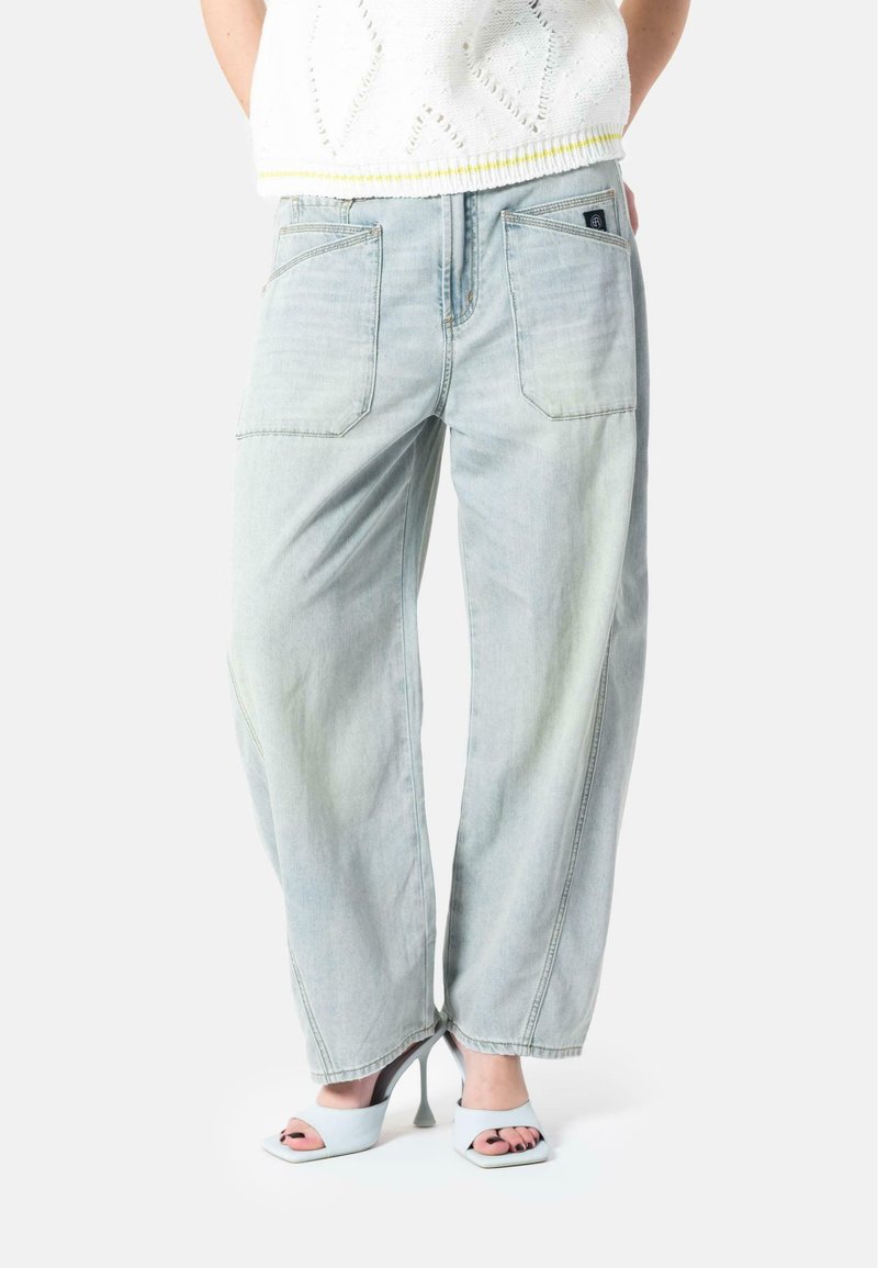 Lyseblå, høy midje jeans med en avslappet passform, med baklommer og subtil falming. Kombinert med lyse blokkhelte sandaler.