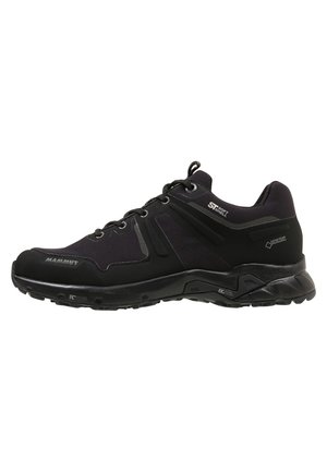 Chaussure de randonnée noire à bout bas avec tige en softshell, membrane imperméable Gore-Tex, semelle robuste, marquage Mammut et étiquettes techniques sur le côté.