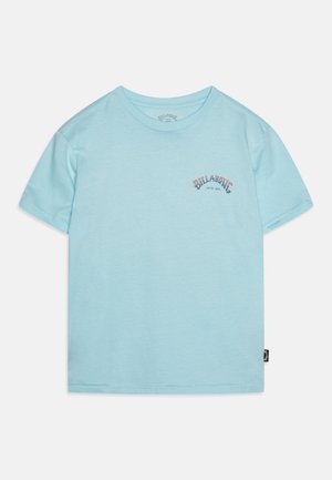 Lyseblå t-shirt med korte ærmer, lille “Billabong”-tekst og “Since 1973”-logo på venstre bryst, vist fladt på hvid baggrund.