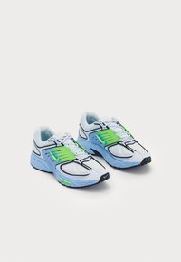 Scarpe da corsa con tomaia in mesh azzurro chiaro, dettagli neri e sovrapposizioni in plastica verde. Presentano lacci bianchi e suola in gomma nera texturizzata.