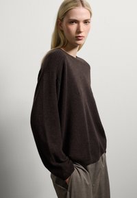 Maglione marrone a maglia con collo rotondo, spalle abbassate e dettagli a coste alle spalle e all'orlo. Vestibilità classica, texture morbida, design minimal.