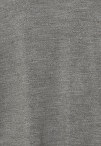 Grau Stoffnähe mit glatter Textur und subtilen Farbvariationen, die eine weiche, gestrickte Optik aufweisen.
