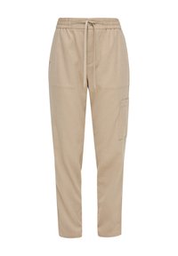 Beige joggerbroek van zacht materiaal, met een elastische tailleband met trekkoord, zijzakken en een cargozak op de bovenbeen.