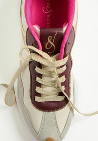 Sneaker con tomaia in pelle beige, dettagli in pelle bordeaux, punta in suede grigio argento e lacci dorati. Fodera interna di un brillante colore rosa.