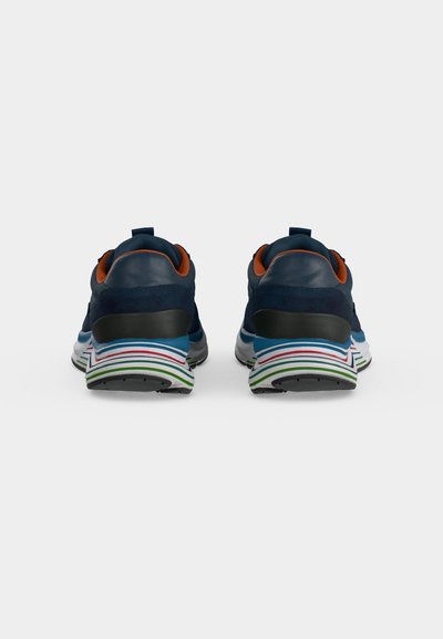 Paire de chaussures de sport bleu marine avec semelles rayées multicolores et doublure intérieure orange, vues de dos sur fond blanc.