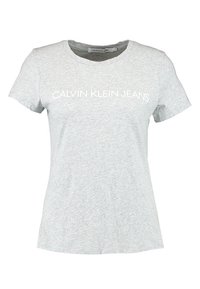 Light gray t-shirt made of cotton. Features a round neck and short sleeves. "CALVIN KLEIN JEANS" printed in white across the front.