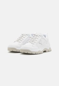 Sneakers bianchi in pelle con dettagli testurizzati, design con lacci e suola spessa beige, con logo laterale.