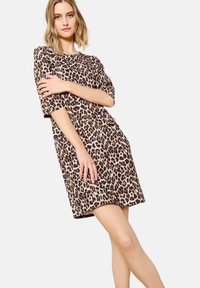 Beige- und braunfarbendes Kleid mit Leopardenmuster und kurzen Ärmeln, das einen lässigen Schnitt und eine weiche Textur aufweist. Es hat sichtbare Seitentaschen und einen runden Ausschnitt.