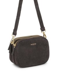 Tmavosivá semišová kabelka cez rameno so zlatými zipsami. Má zaoblený obdĺžnikový tvar a nastaviteľný popruh. Embosované logo Kazar.