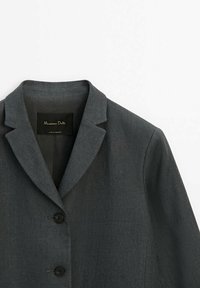 Blazer gris foncé sur mesure avec col à revers cranté et deux boutons noirs à l'avant, présenté à plat sur fond blanc.