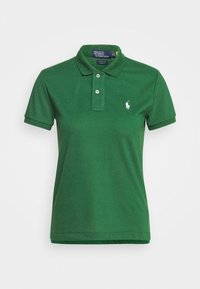 Grön polo skjorta av mjukt tyg, med en klassisk krage, två knappar i placket och en broderad logga på vänster bröst.