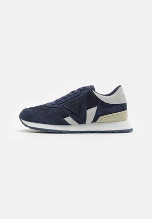 Sneakers blu navy realizzati in materiali scamosciati e in rete, con un logo triangolare, dettagli grigi a contrasto e un design della suola testurizzato.