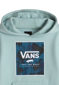 Mintgrön hoodie med ett grafiskt tryck som har svarta silhuetter och palmer, med Vans-logotypen och skateboarddesign.