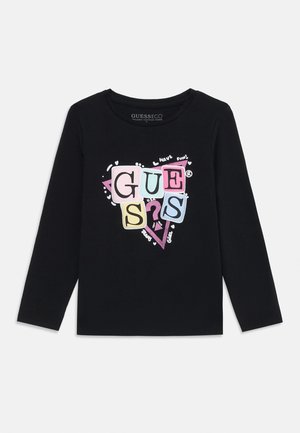 Camiseta de manga larga negra en algodón orgánico con un colorido estampado gráfico en la parte frontal que lleva la palabra "GUESS" y acentos juguetones.