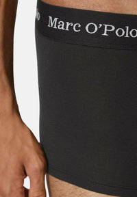 Boxer neri realizzati in tessuto morbido con una vestibilità elasticizzata. Presentano un'ampia vita elastica con il logo "Marc O'Polo" in bianco.
