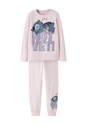 Pyjama enfant rose clair avec un personnage de dessin animé endormi et le texte "NOT YET!" en haut et aux poignets des jambes.