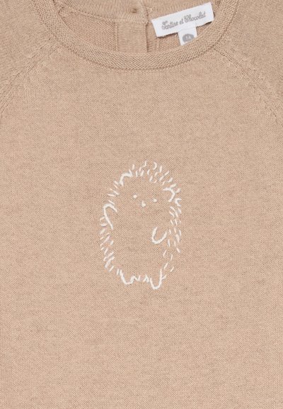 Beige genser med et hvitt brodert pinnsvin design i midten. Myk tekstur med rund hals og raglanermer.