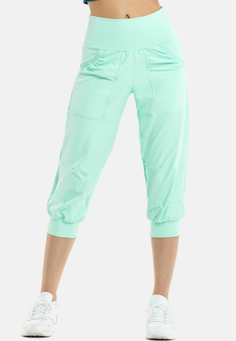 Pantaloni capri verde menta realizzati in un materiale elastico, con polsini aderenti, tasche laterali e una cintura larga con dettaglio testurizzato.