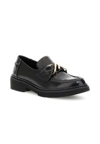 Mocassino in vernice nera con dettaglio a fiocco e hardware dorato, caratterizzato da una punta tonda, cuciture decorative e una suola in gomma spessa.