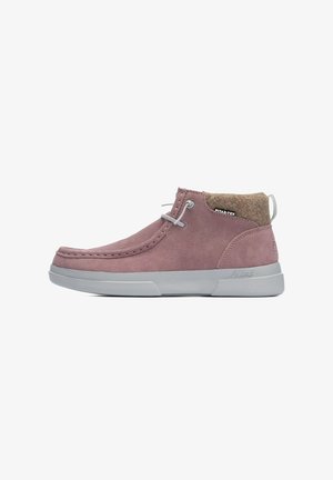 Helle rosa Wildleder-Stiefeletten mit grauer Gummisohle, abgerundeter Spitze und einem Filzkragen. Mit grauen Schnürsenkeln und einem Logo an der Seite.